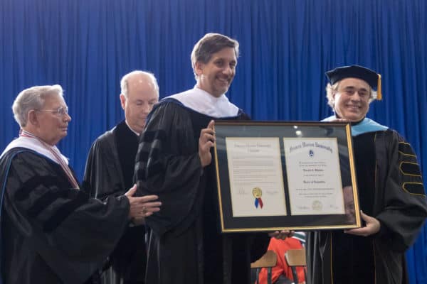 Faculty pose on stage.