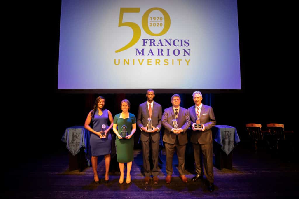 FMU's Alumni Award winners pose for a photo on the stage of the FMU PAC.