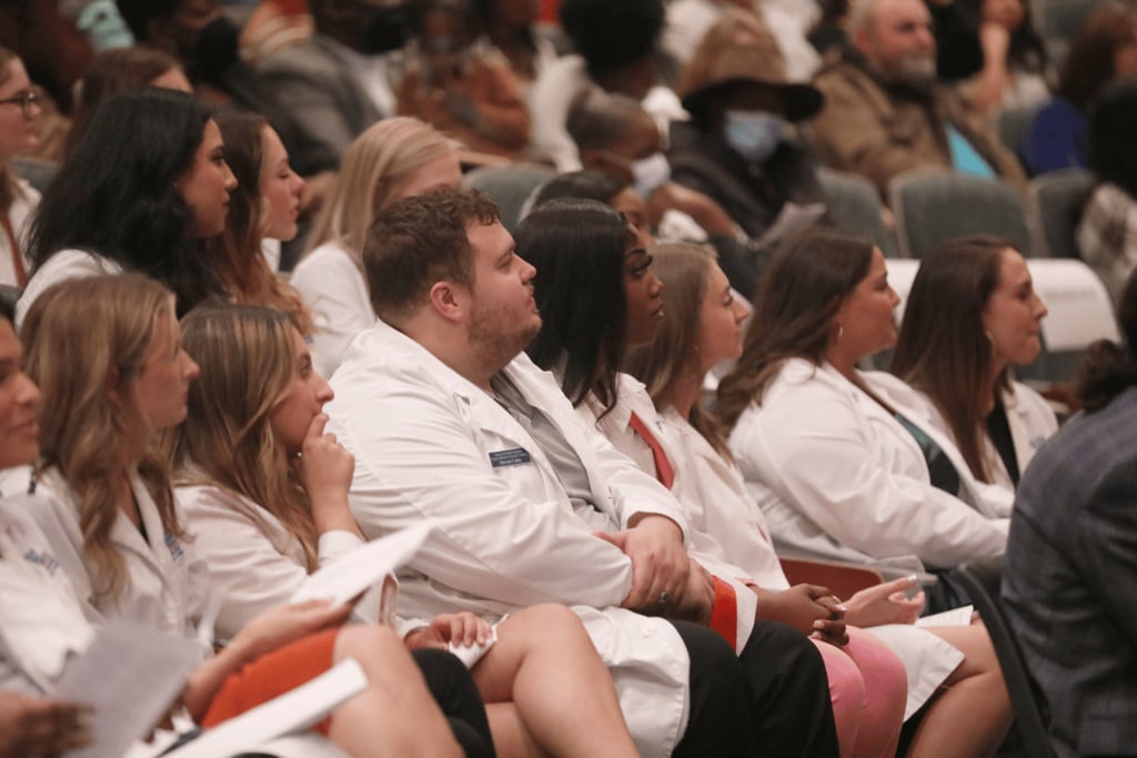 A group of nursing students wearing lab coats.